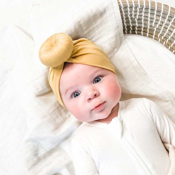 A baby wearing a Tiny Knot Co Bamboo Baby Knotted Headwrap.