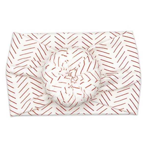 A red and white Tiny Knot Co baby headwrap with a chevron pattern.